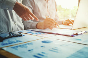 Business people signing a document by laptop