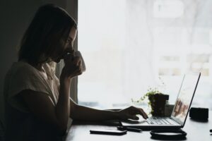 woman watching webinar with a cup of tea