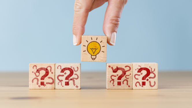 Concept creative idea, solution and innovation. Hand picked wooden cube block with light bulb icon