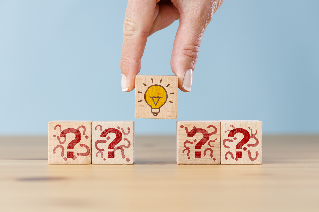 Concept creative idea, solution and innovation. Hand picked wooden cube block with light bulb icon