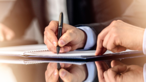 hands signing a document